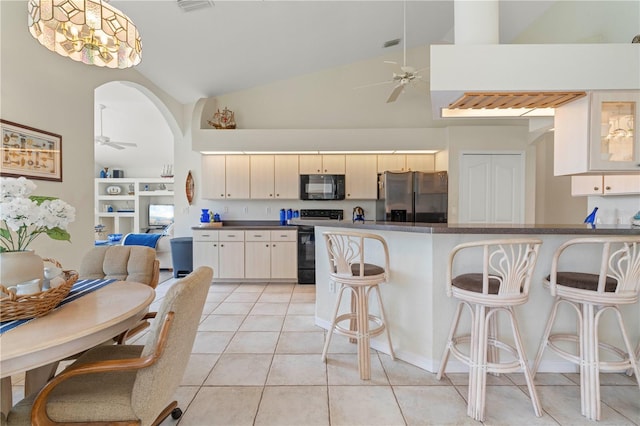 kitchen with ceiling fan, range with electric stovetop, a kitchen bar, and stainless steel refrigerator with ice dispenser