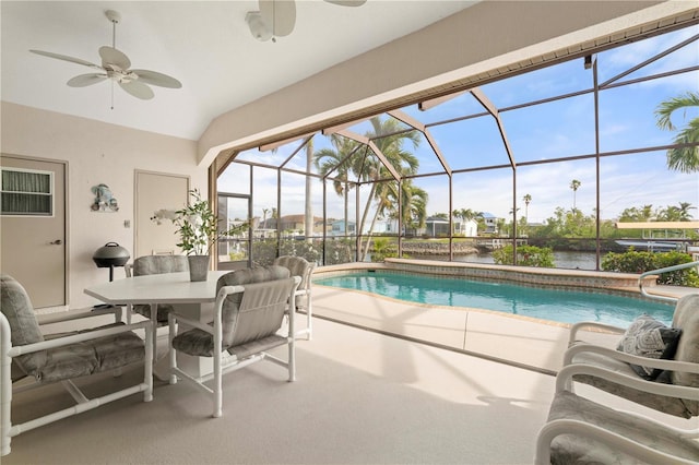 view of pool featuring ceiling fan, glass enclosure, a patio area, and a water view