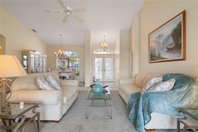 living room featuring ceiling fan with notable chandelier, carpet flooring, high vaulted ceiling, and french doors