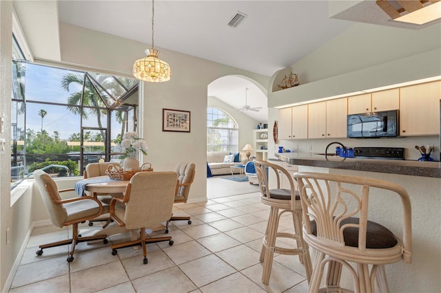 tiled dining room featuring sink and lofted ceiling