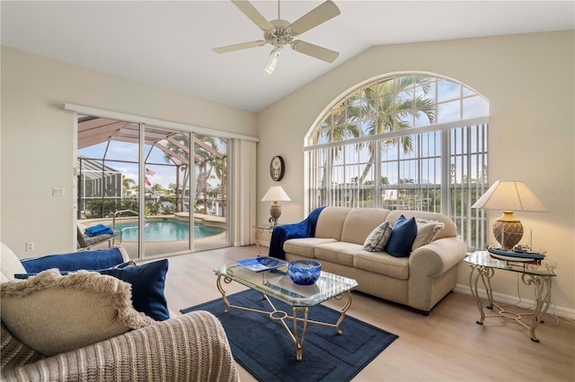 living room featuring light hardwood / wood-style floors, ceiling fan, and vaulted ceiling