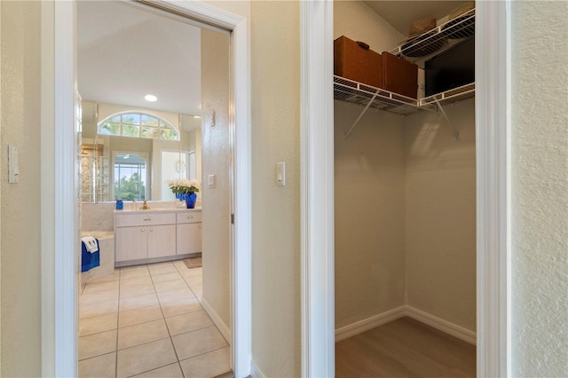 walk in closet with sink and light tile patterned flooring