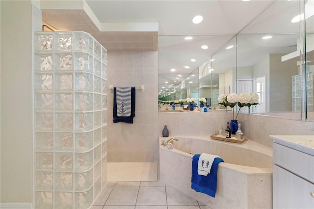 bathroom featuring vanity, tile patterned floors, tile walls, and plus walk in shower