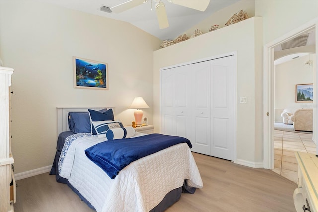 bedroom with a closet, ceiling fan, light hardwood / wood-style floors, and lofted ceiling