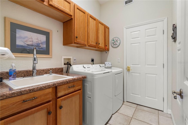 laundry area featuring sink, light tile patterned flooring, cabinets, and separate washer and dryer