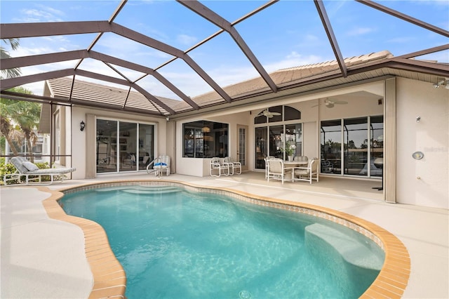 view of swimming pool with ceiling fan, a patio, and a lanai