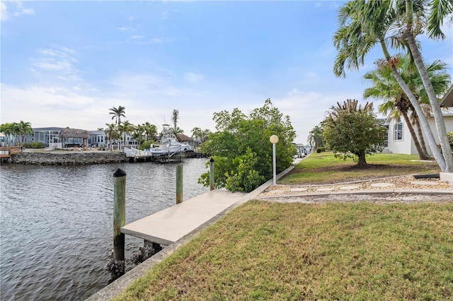 view of dock featuring a water view and a lawn