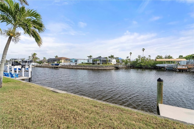 dock area with a lawn and a water view