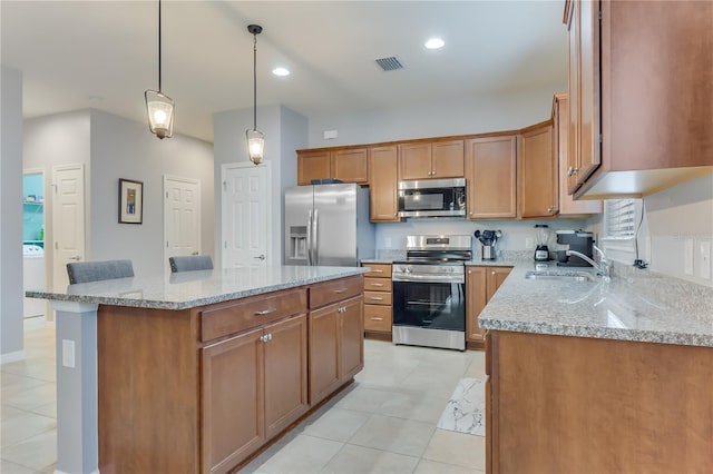 kitchen featuring a kitchen island, stainless steel appliances, sink, hanging light fixtures, and light stone counters