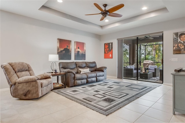 tiled living room featuring ceiling fan and a raised ceiling