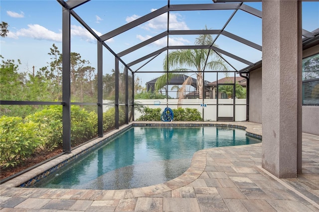 view of swimming pool with a patio area and a lanai