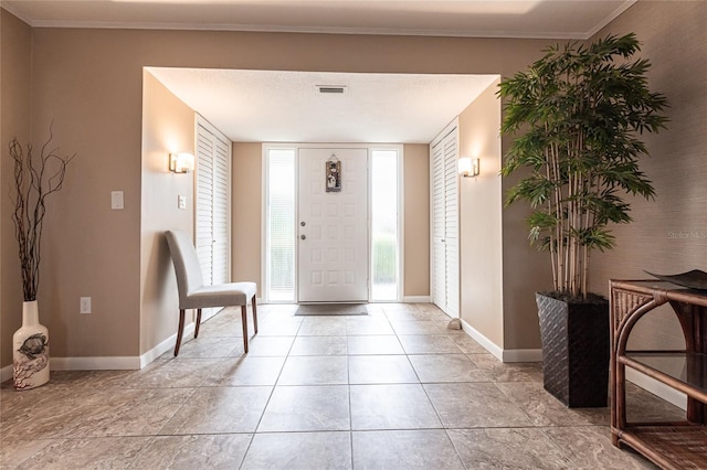 foyer entrance featuring crown molding