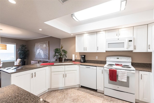 kitchen featuring white cabinetry, white appliances, and kitchen peninsula