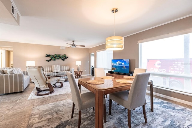 dining area with ceiling fan and ornamental molding