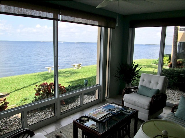 sunroom featuring ceiling fan, a water view, and plenty of natural light