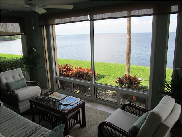 sunroom featuring ceiling fan, a water view, and a wealth of natural light