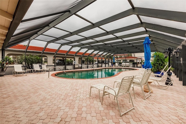 view of swimming pool featuring a patio area and a lanai