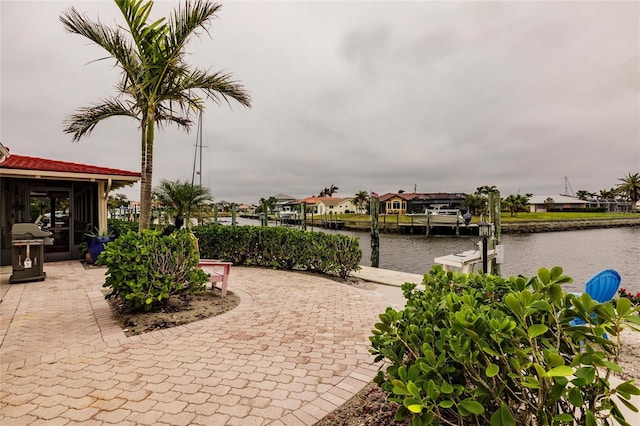 view of patio featuring a grill, a dock, and a water view