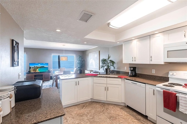 1 Colony Point Dr Unit A19, Punta Gorda, FL 33950 - kitchen with visible vents, white cabinets, a textured ceiling, white appliances, and a peninsula