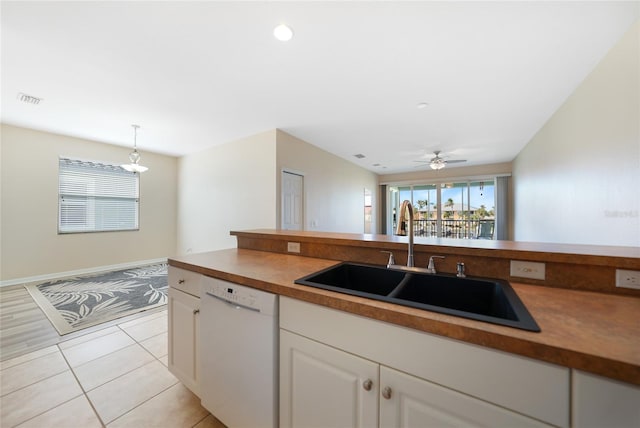 kitchen featuring light tile patterned floors, sink, dishwasher, white cabinets, and decorative light fixtures