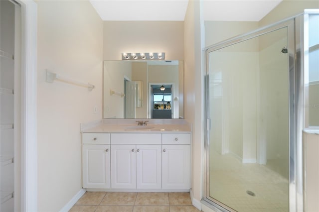 bathroom featuring tile patterned floors, a shower with shower door, and vanity