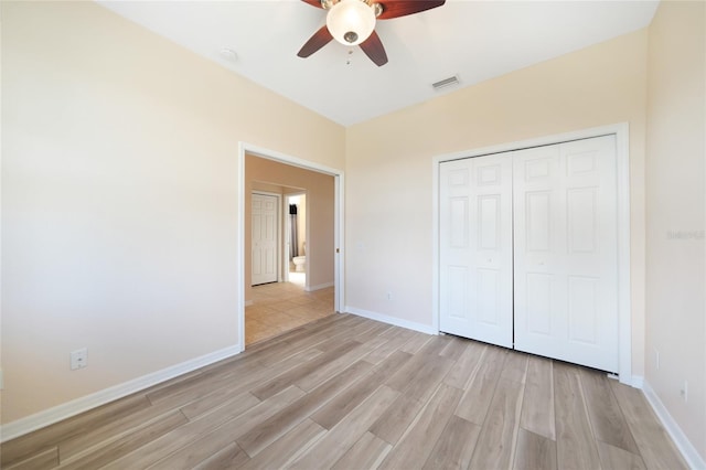 unfurnished bedroom with ceiling fan, a closet, and light hardwood / wood-style flooring