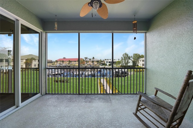 unfurnished sunroom with ceiling fan