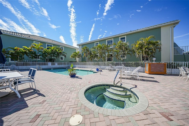 view of swimming pool with a hot tub and a patio