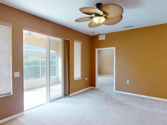 carpeted spare room featuring ceiling fan