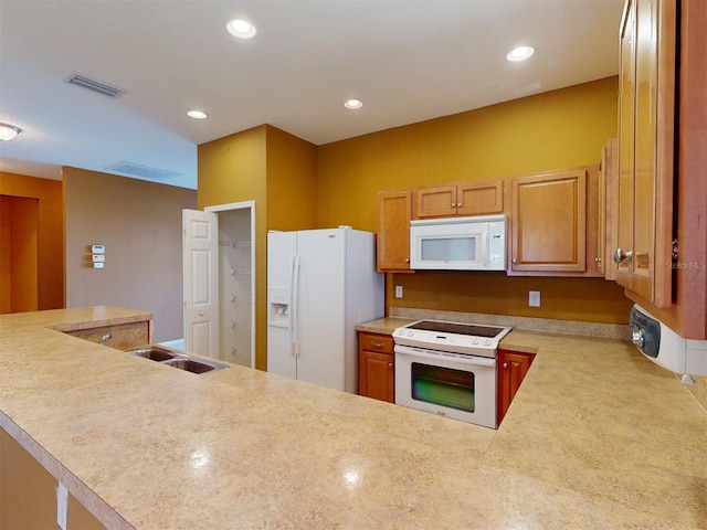 kitchen featuring sink, white appliances, and kitchen peninsula