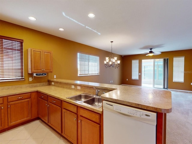 kitchen featuring sink, dishwasher, kitchen peninsula, pendant lighting, and light colored carpet