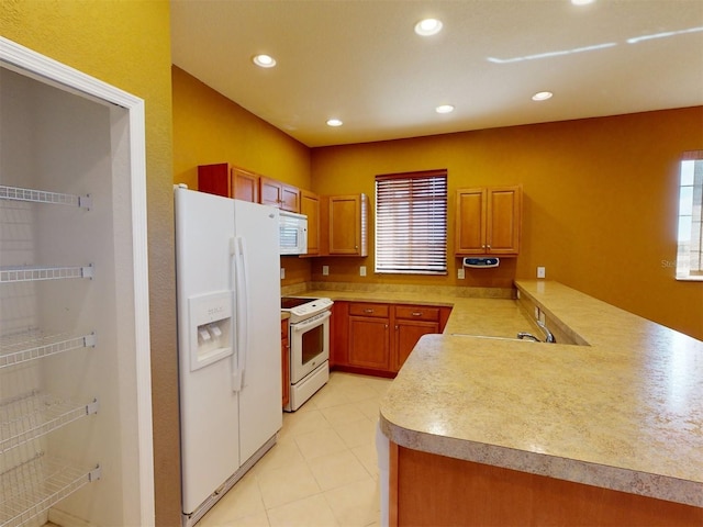 kitchen featuring white appliances and kitchen peninsula