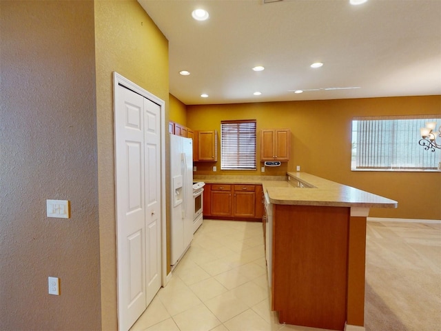 kitchen with white appliances, a healthy amount of sunlight, and kitchen peninsula