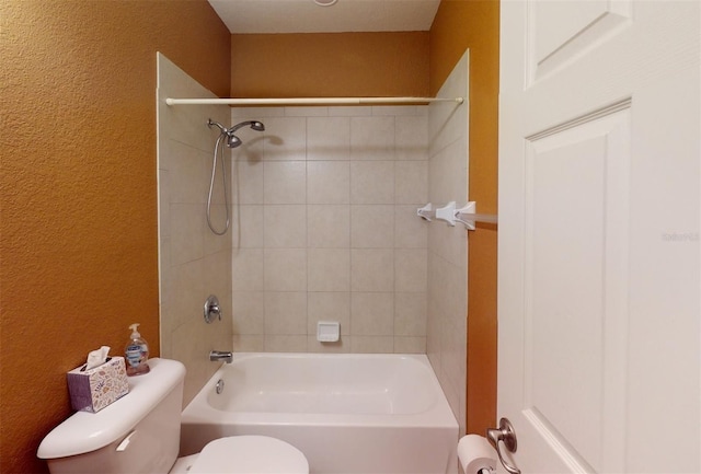 bathroom featuring tiled shower / bath and toilet