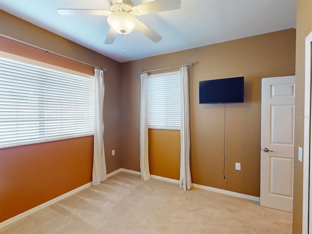 unfurnished bedroom featuring light colored carpet and ceiling fan