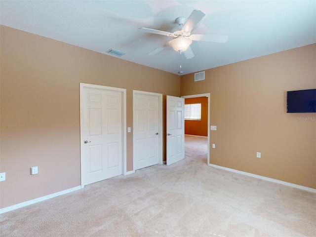 unfurnished bedroom featuring light colored carpet and ceiling fan