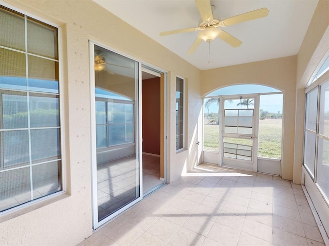 unfurnished sunroom featuring ceiling fan