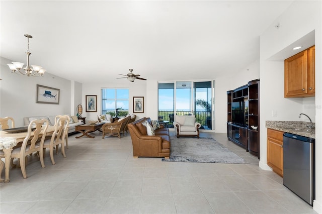 living room featuring sink, light tile patterned floors, and ceiling fan with notable chandelier