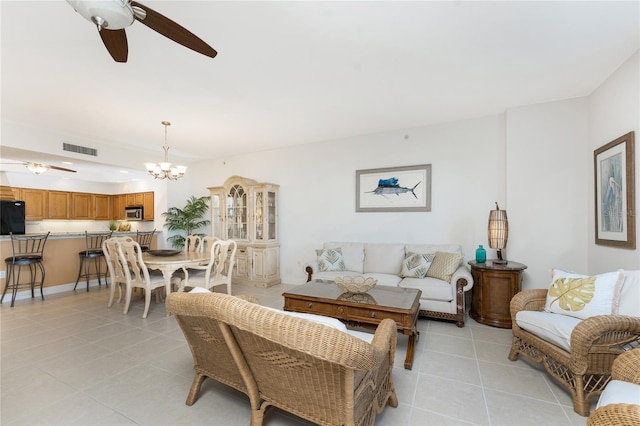 tiled living room featuring ceiling fan with notable chandelier