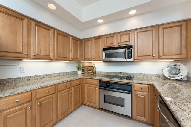 kitchen featuring light stone countertops, appliances with stainless steel finishes, and light tile patterned floors