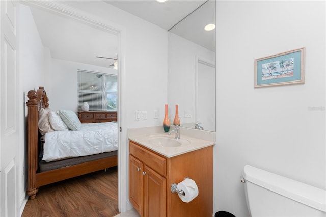 bathroom with vanity, toilet, and hardwood / wood-style floors