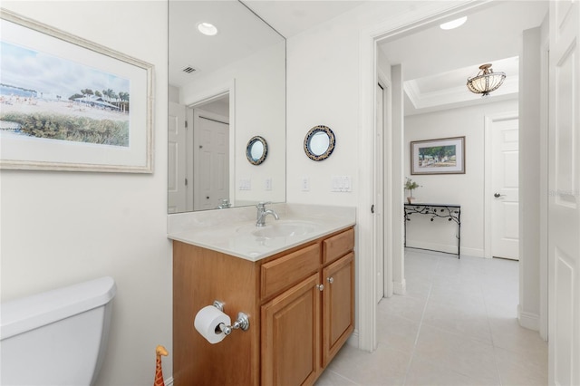 bathroom with vanity, toilet, a raised ceiling, and tile patterned flooring