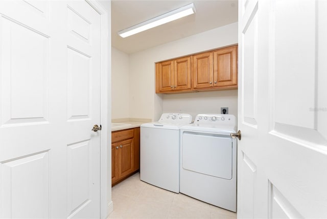 washroom featuring light tile patterned flooring, cabinets, and washer and dryer