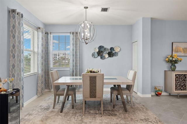 tiled dining space featuring an inviting chandelier and plenty of natural light