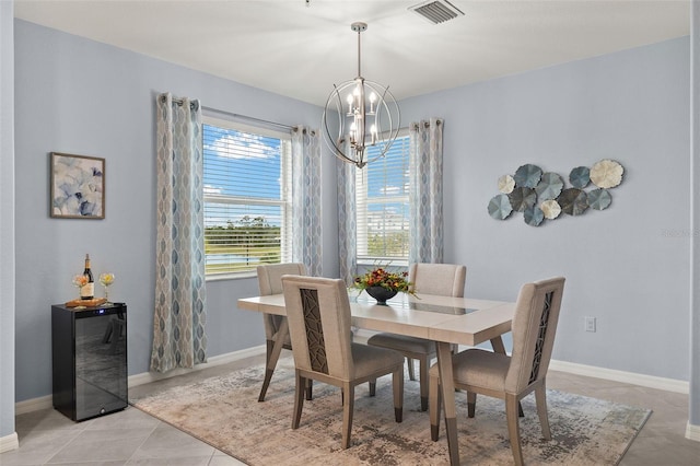 dining area featuring beverage cooler, a chandelier, and light tile patterned flooring