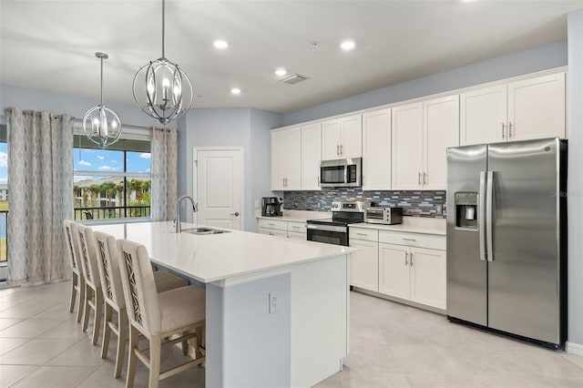 kitchen featuring sink, a center island with sink, white cabinets, and appliances with stainless steel finishes