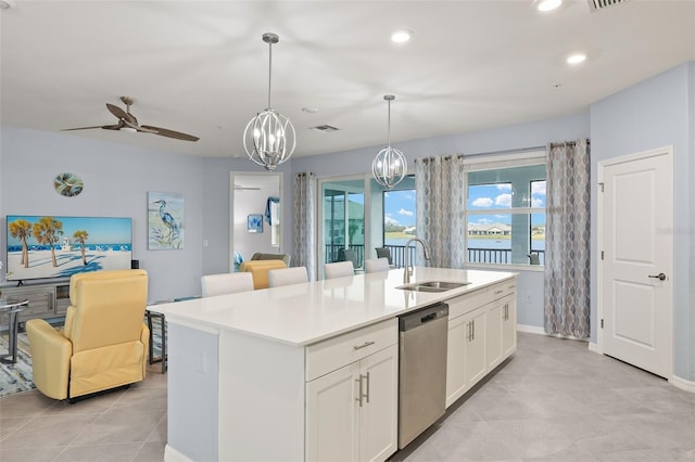 kitchen featuring a kitchen island with sink, sink, decorative light fixtures, and dishwasher