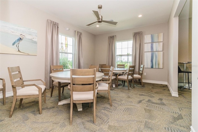 carpeted dining area with plenty of natural light and ceiling fan