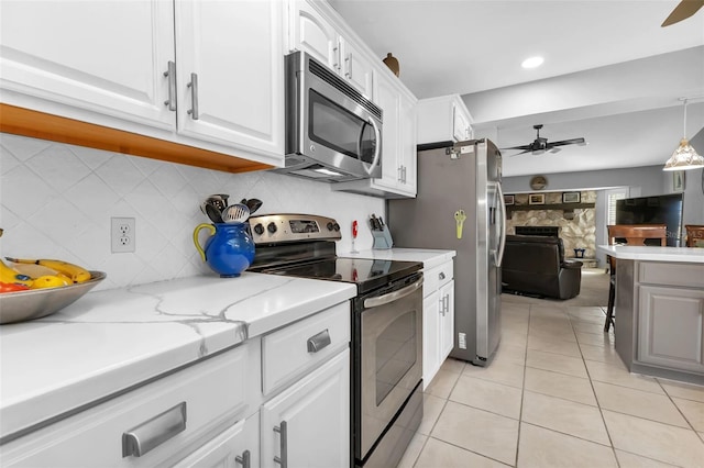 kitchen featuring ceiling fan, appliances with stainless steel finishes, decorative light fixtures, white cabinets, and light tile patterned floors