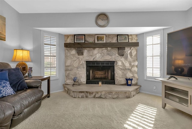 carpeted living room featuring a stone fireplace